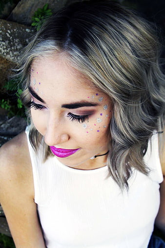 Woman with glitter makeup and bright pink lipstick