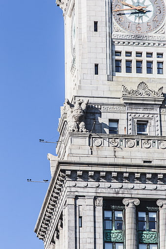 Low angle view of ornate clock tower architecture against blue sky