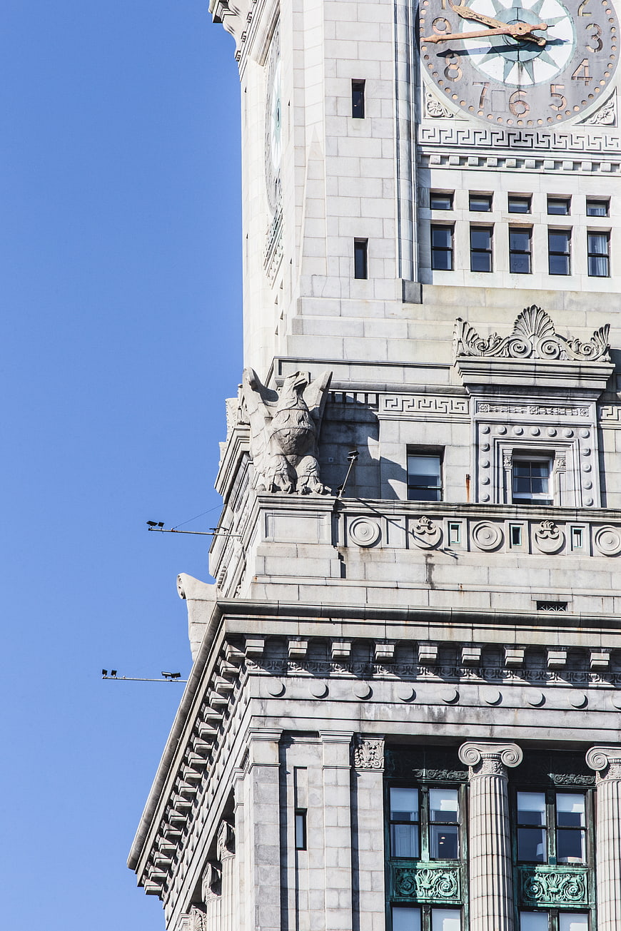 Low angle view of ornate clock tower architecture against blue sky