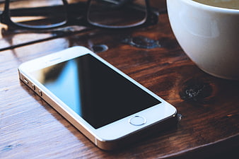White Smartphone on Wooden Table with Coffee Cup