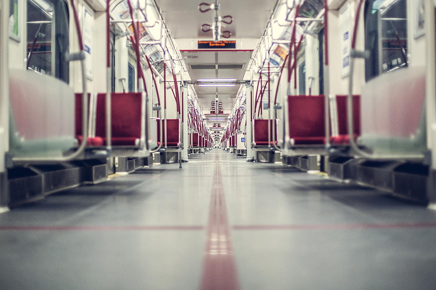 Empty subway car interior with red seats and perspective view