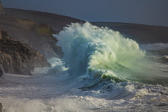 Dramatic Ocean Wave Crashing Against Rocky Coastline in Cornwall