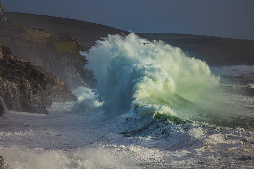 Dramatic Ocean Wave Crashing Against Rocky Coastline in Cornwall