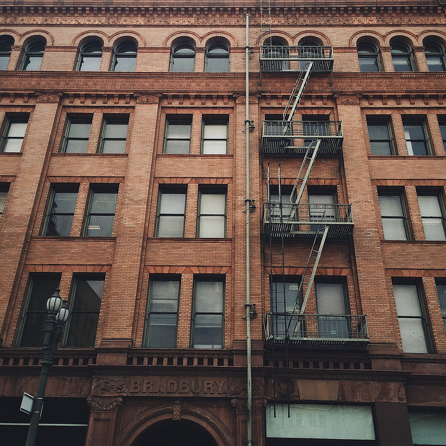 Red brick building facade with fire escape and Bradbury sign
