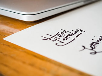 Hand Lettering Practice on Paper with Laptop