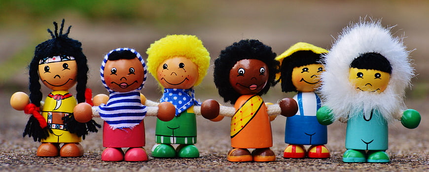 Diverse wooden peg dolls holding hands representing global unity