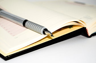 Silver Fountain Pen Resting On Open Notebook Page