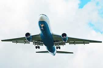 Low Angle View of Blue and White Airplane Landing
