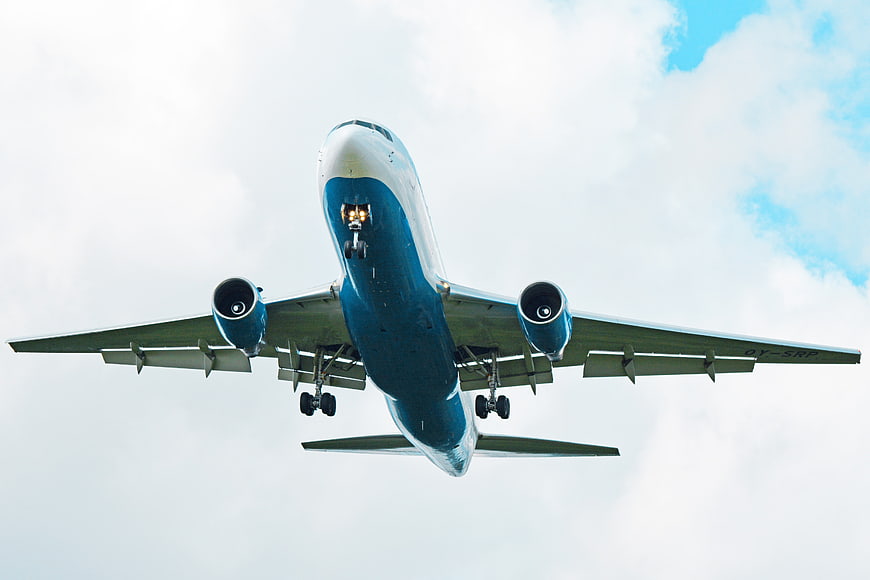 Low Angle View of Blue and White Airplane Landing