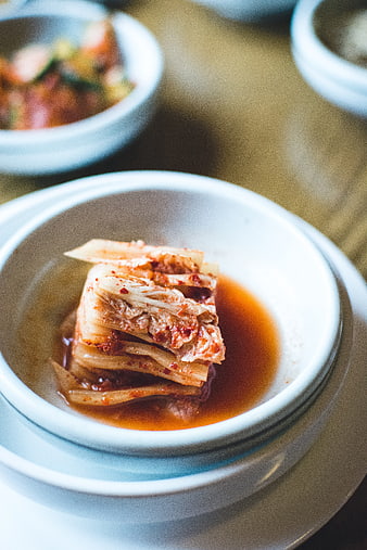 Close-up of spicy fermented kimchi in a white ceramic bowl