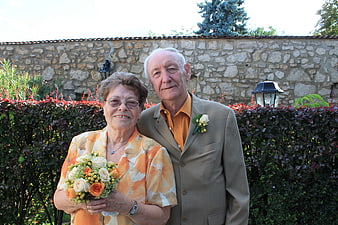 Senior couple posing outdoors with bouquet and boutonniere