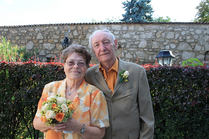 Senior couple posing outdoors with bouquet and boutonniere
