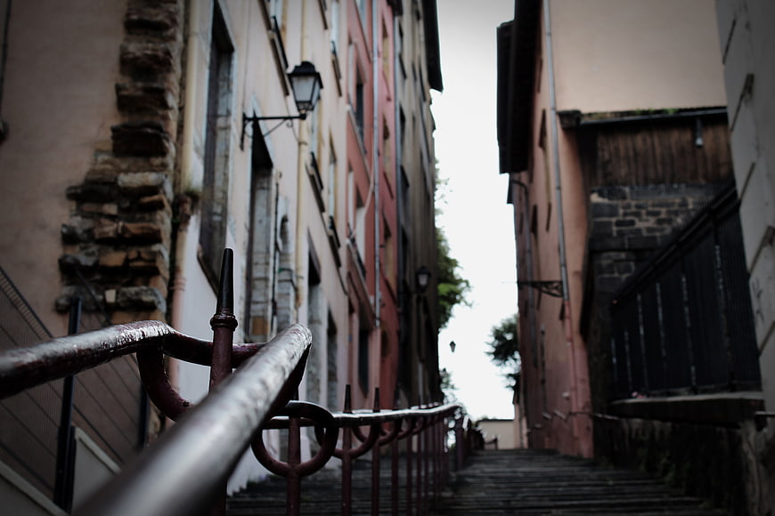 Narrow European Alley with Stairs and Rusty Railing