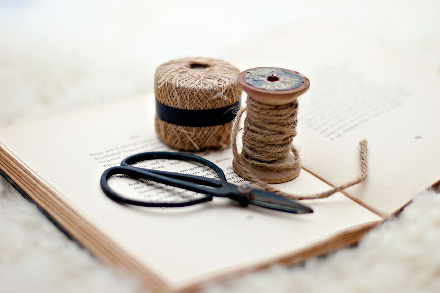 Vintage sewing supplies on an open book