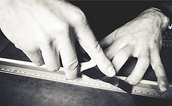 Hands cutting material with utility knife and ruler
