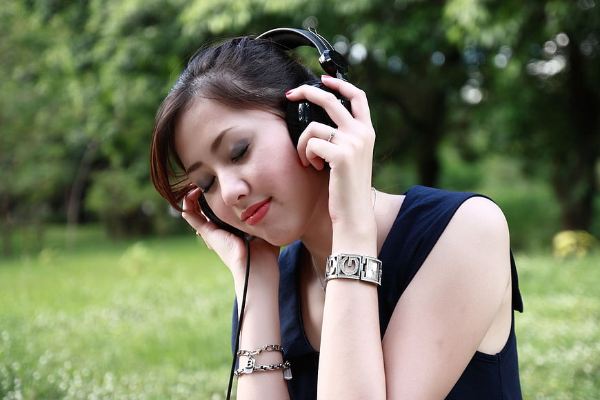 Young woman listening to music with headphones in a park
