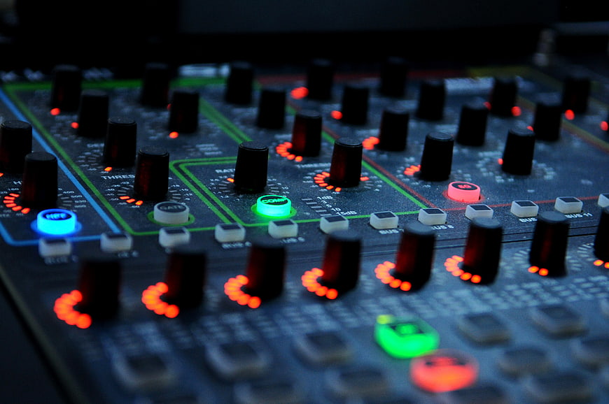 Close-up of DJ mixer with glowing knobs and buttons