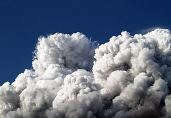 Dramatic White Cumulus Clouds Against Deep Blue Sky