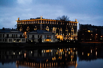 Illuminated historic building at night with water reflections