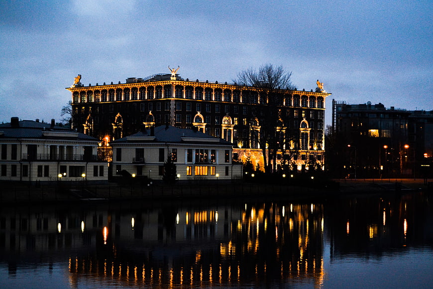 Illuminated historic building at night with water reflections