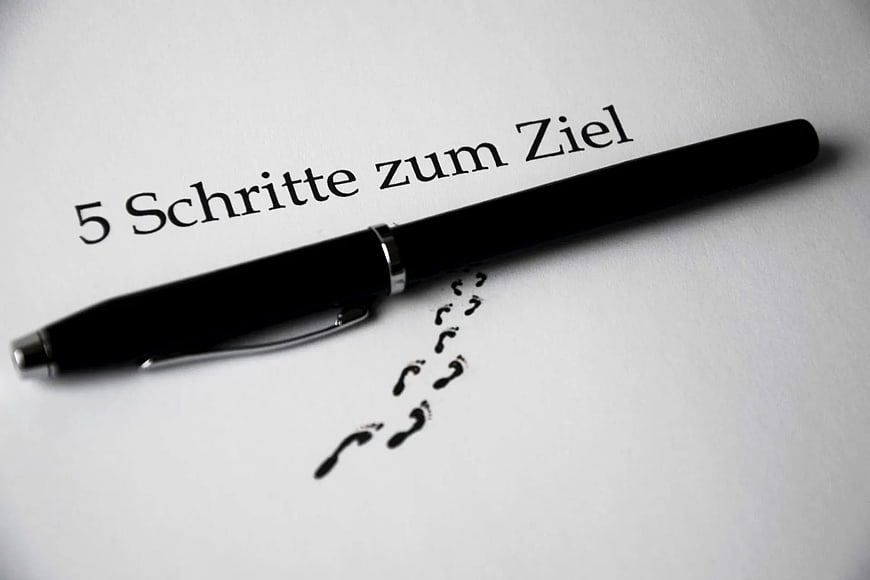 Black Pen on Paper with German Text and Footprints