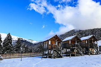 Rustic wooden cabins in snowy mountain landscape