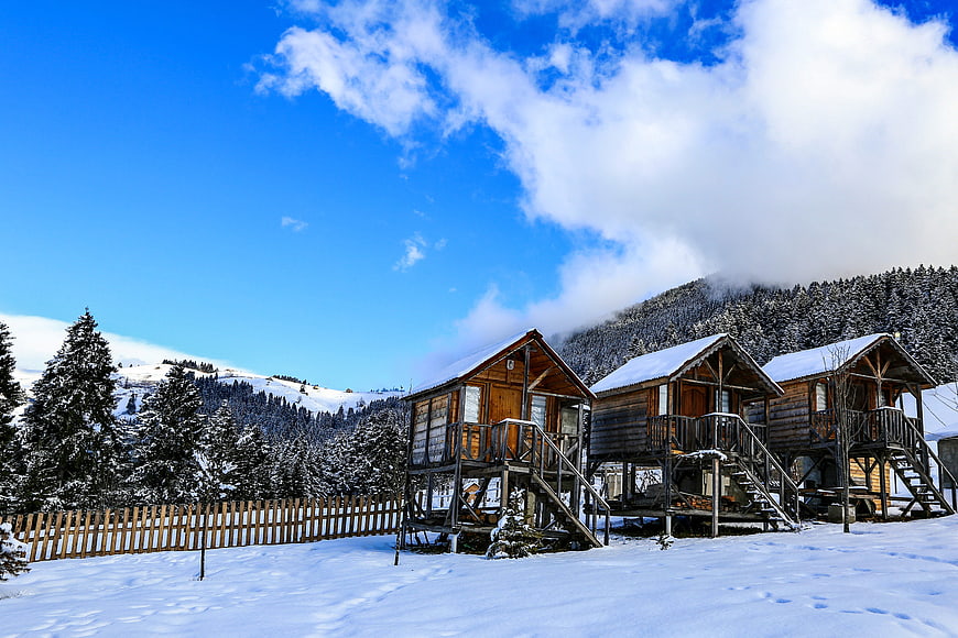 Rustic wooden cabins in snowy mountain landscape