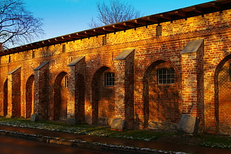 Golden hour sunlight on historic red brick monastery wall