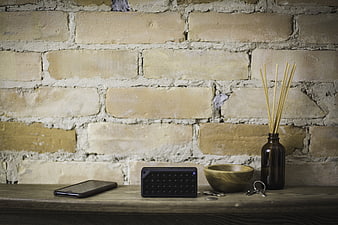 Bluetooth speaker, smartphone, and keys on rustic wooden shelf