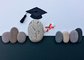 Graduation cap and diploma on stones concept