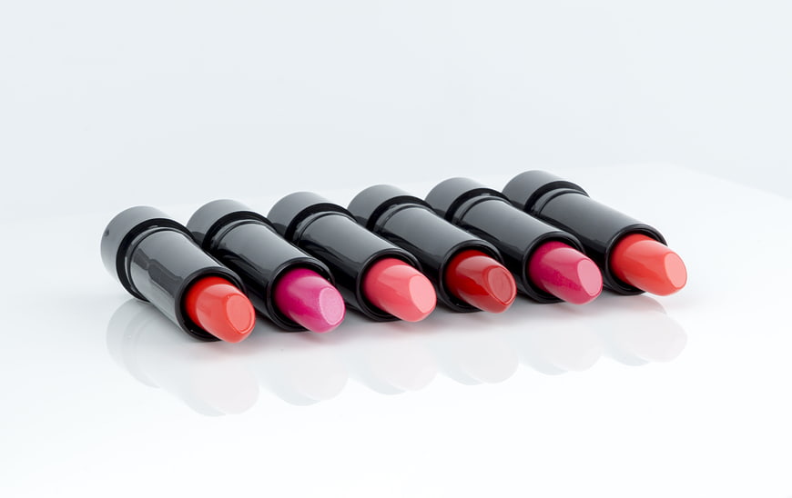 Row of colorful lipsticks on white background