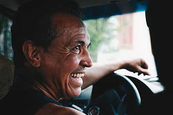Happy Middle-Aged Man Laughing While Driving Car