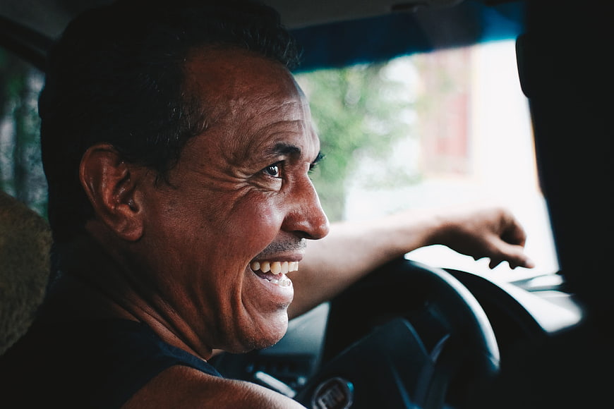Happy Middle-Aged Man Laughing While Driving Car