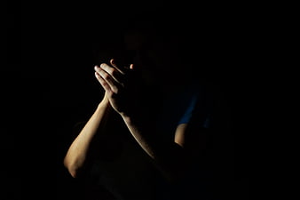 Silhouette of hands clapping in darkness