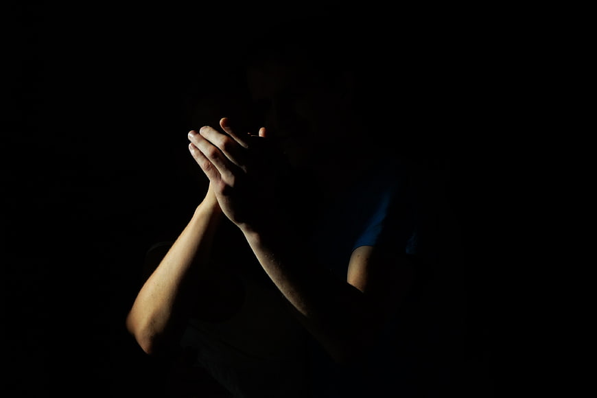 Silhouette of hands clapping in darkness