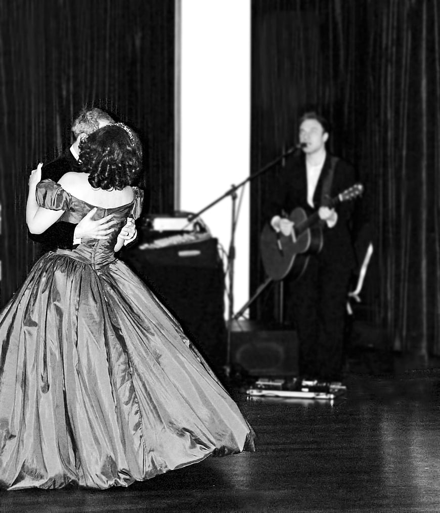 Couple dancing in formal gown with musician playing guitar