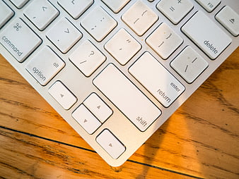 Close-up of white computer keyboard on wooden desk
