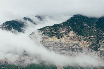 Misty Mountain Peaks with Clouds and Forest