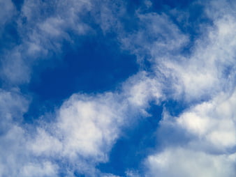 Blue Sky with Fluffy White Clouds Background