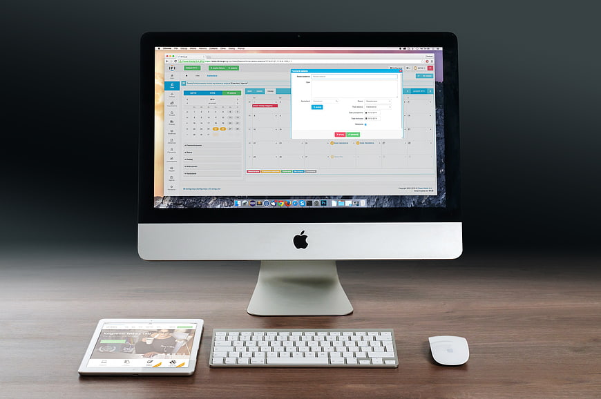 Apple iMac, Keyboard, Mouse, and Tablet on Wooden Desk