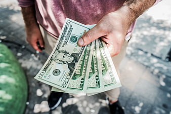 Man Holding Fan of Twenty Dollar Bills
