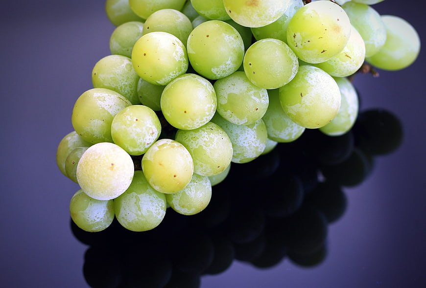 Fresh Green Grapes on Dark Reflective Surface