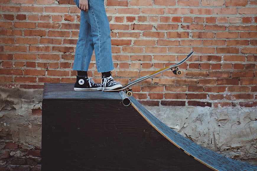 Skateboarder on ramp against brick wall