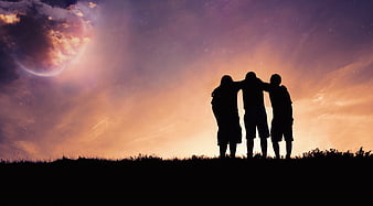 Silhouette of three friends watching a surreal cosmic sunset