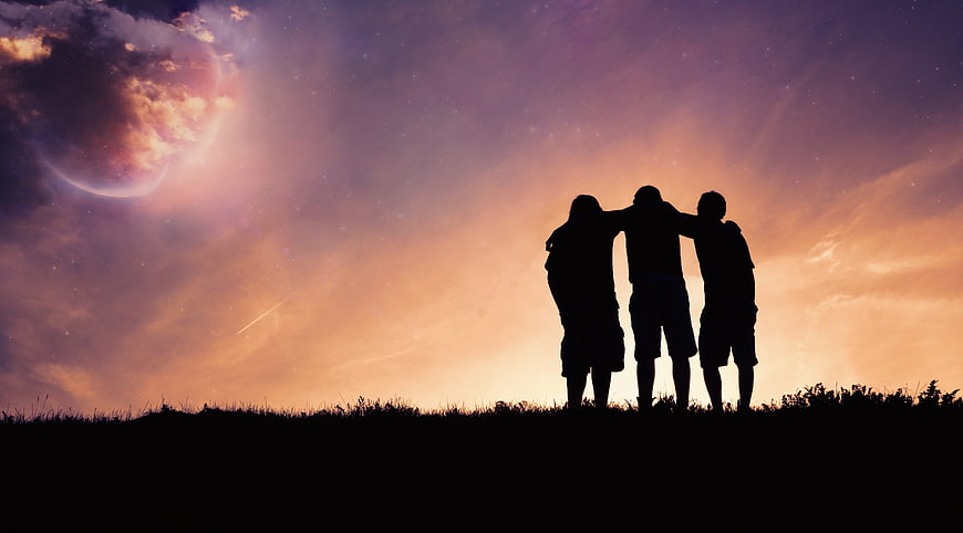 Silhouette of three friends watching a surreal cosmic sunset