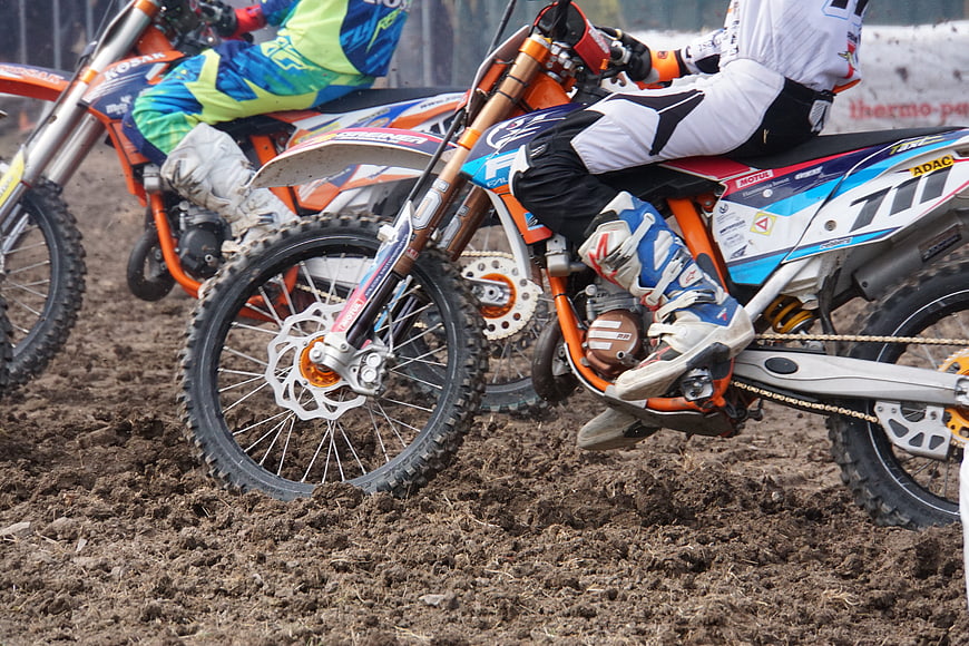 Motocross Riders Racing on Muddy Dirt Track