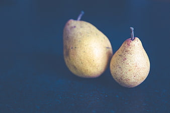 Two ripe pears on a dark blue textured background