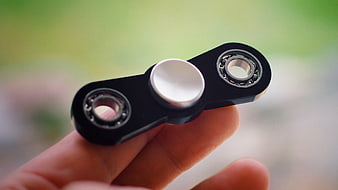Close-up of black fidget spinner held in hand