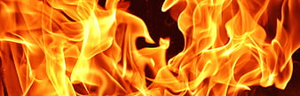 Close-up of intense orange and yellow flames against dark background