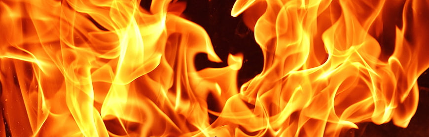 Close-up of intense orange and yellow flames against dark background